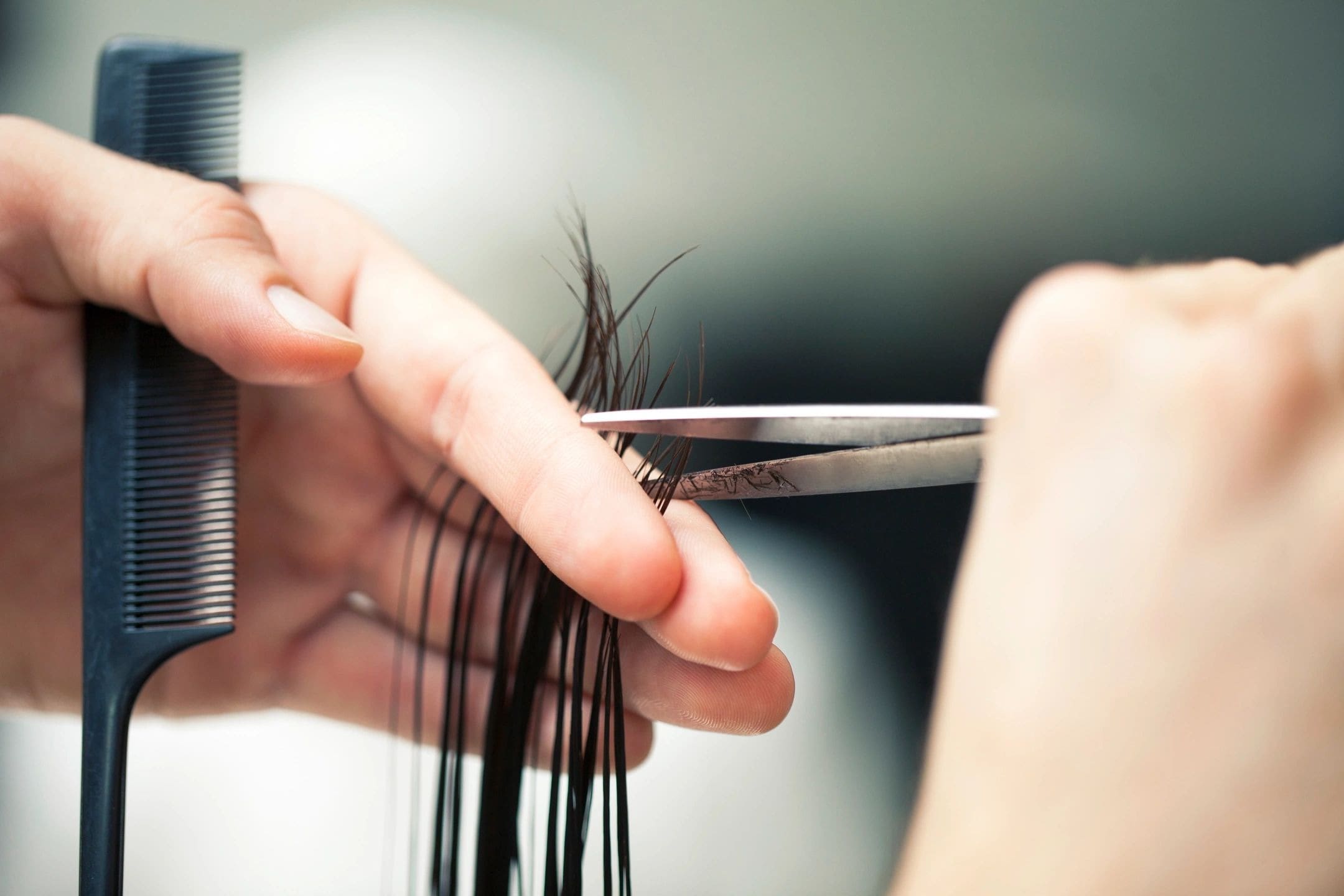 A person cutting their hair with scissors.