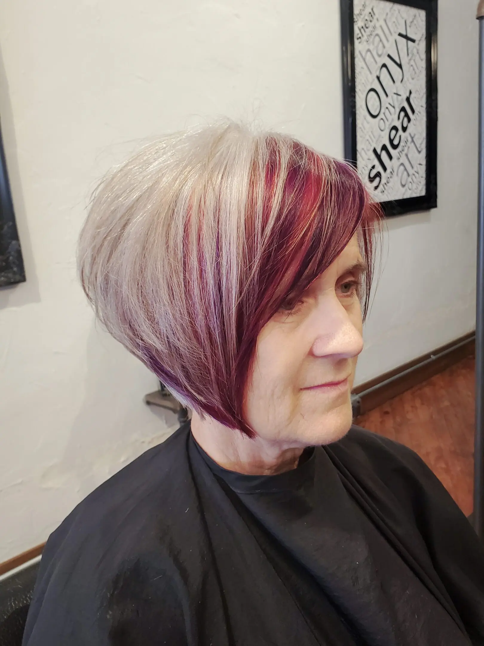 A woman with short hair is sitting in front of a mirror.