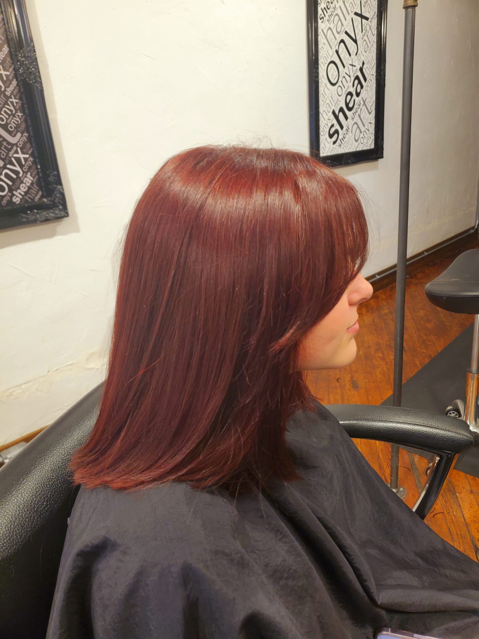 A woman sitting in front of a mirror with red hair.