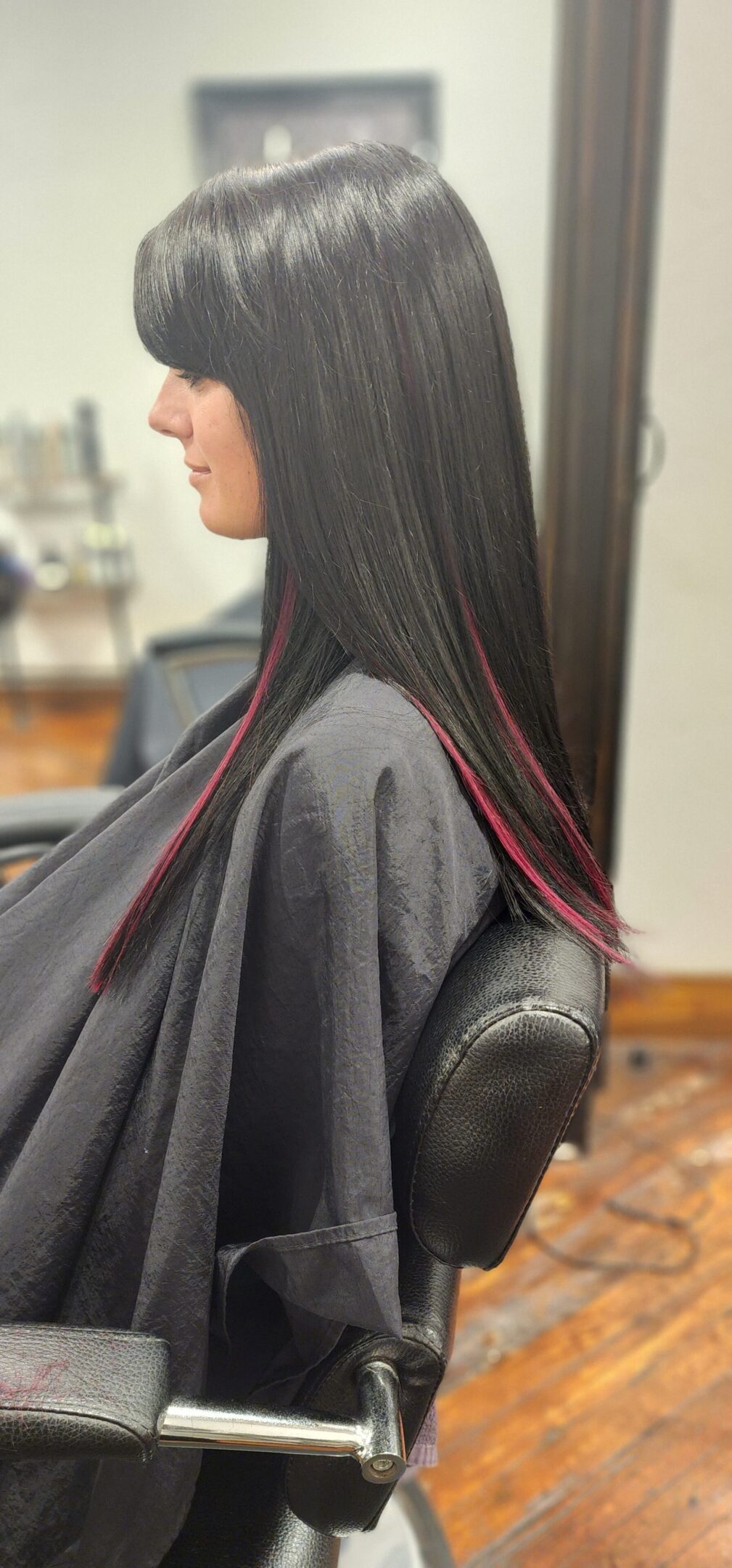 A woman sitting in a chair with long black hair.