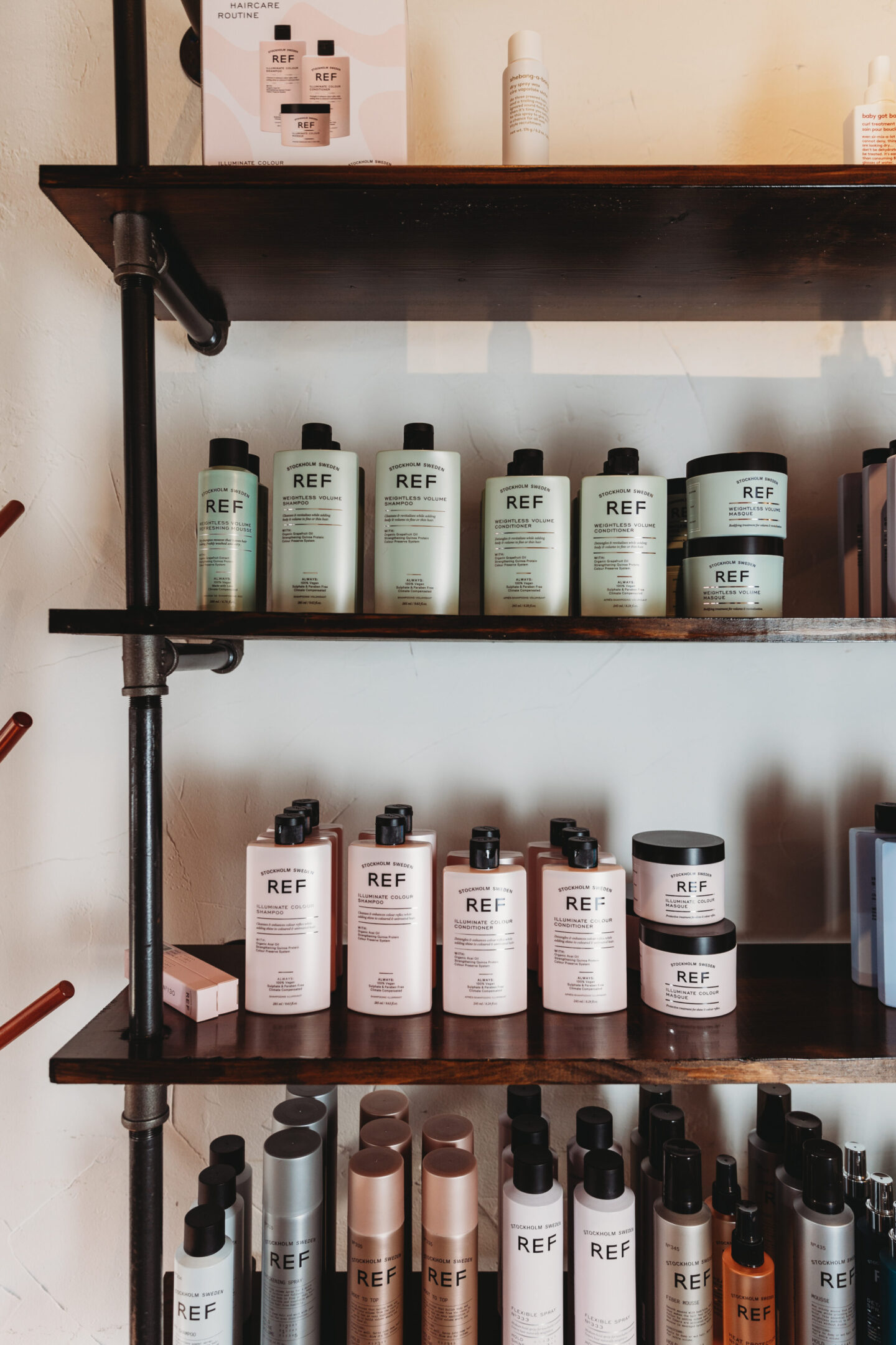 A shelf with many different bottles of hair products.